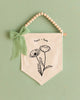 A banner with a floral design and a green ribbon is displayed against a green background.