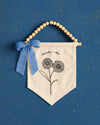a banner with a floral design and a blue ribbon, set against a blue background with scattered gold stars.