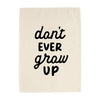Textile with 'don't ever grow up' printed in black on a beige background