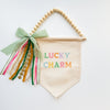 Decorative banner with 'Lucky Charm' text and colorful ribbons on a white background