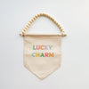 Decorative banner with 'Lucky Charm' text and colorful ribbons on a white background