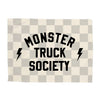 Checkered blanket with 'Monster Truck Society' text and lightning bolt symbols on a white background