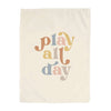 Beige towel with 'play all day' text in pastel colors on a white background
